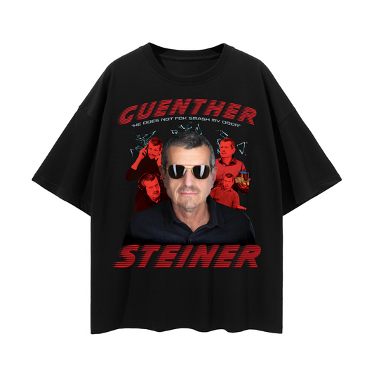 Black T-shirt with a graphic print of a man's face wearing sunglasses, with the text "GUENTHER STEINER." The design includes stylized colors and a boxy layout.